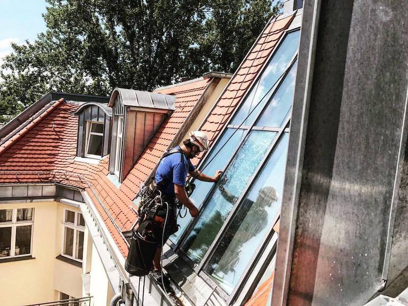 Fassadenkletterer montiert Hitzeschutzfolie Dachfenster